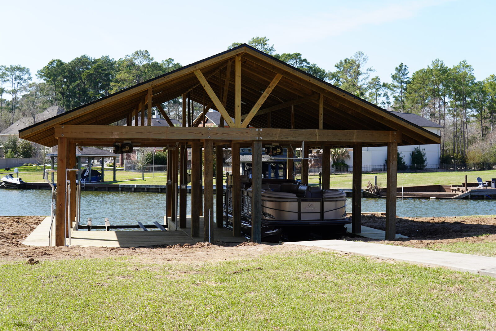 Home 9 Completed wood boathouse with gabled roof and pontoon